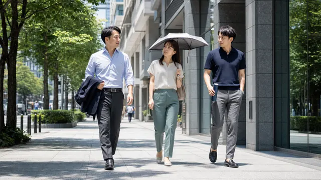 猛暑日の昼休みに日傘と水筒を持って外出する会社員